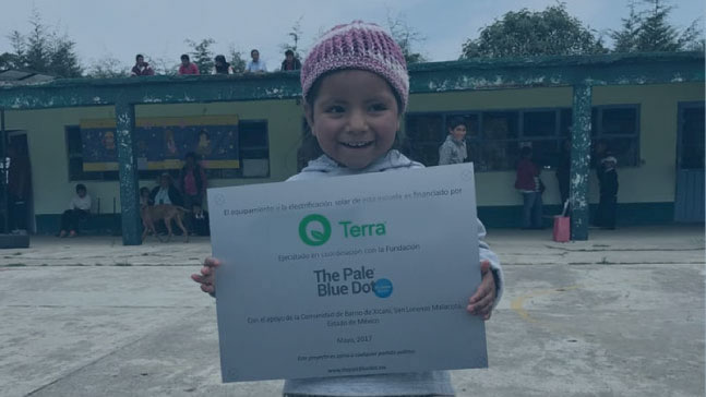 se muestra niña con certificado por instalación de paneles solares para su escuela por parte de Terra Energy